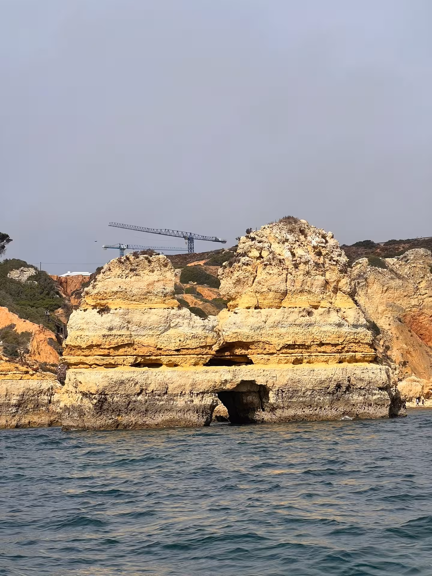 Boat tour view of Ponta da Piedade sea caves and golden cliffs rising from clear Algarve waters near Lagos, Portugal
