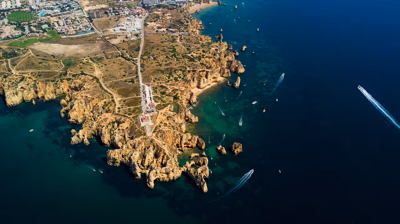 Aerial view of Ponta da Piedade cliffs and boats cruising turquoise Lagos waters on a private Algarve coast tour