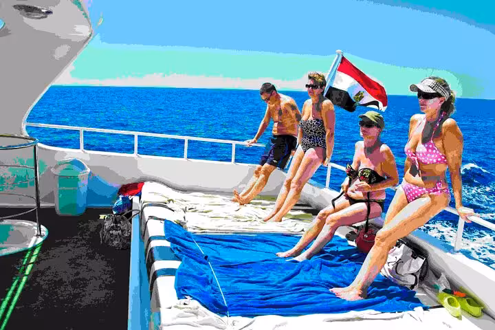 Tourists relax on Red Sea boat deck before swimming with dolphins and banana boat ride adventure