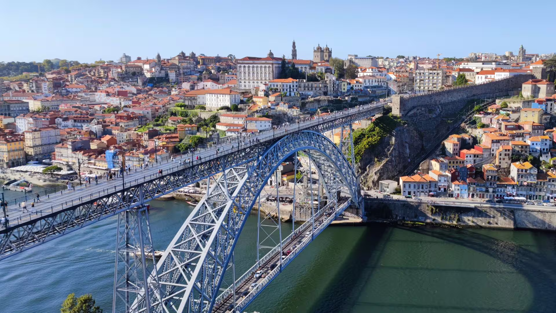 Aerial view of Dom Luís I Bridge spanning the Douro River with Porto's historic architecture in the background.