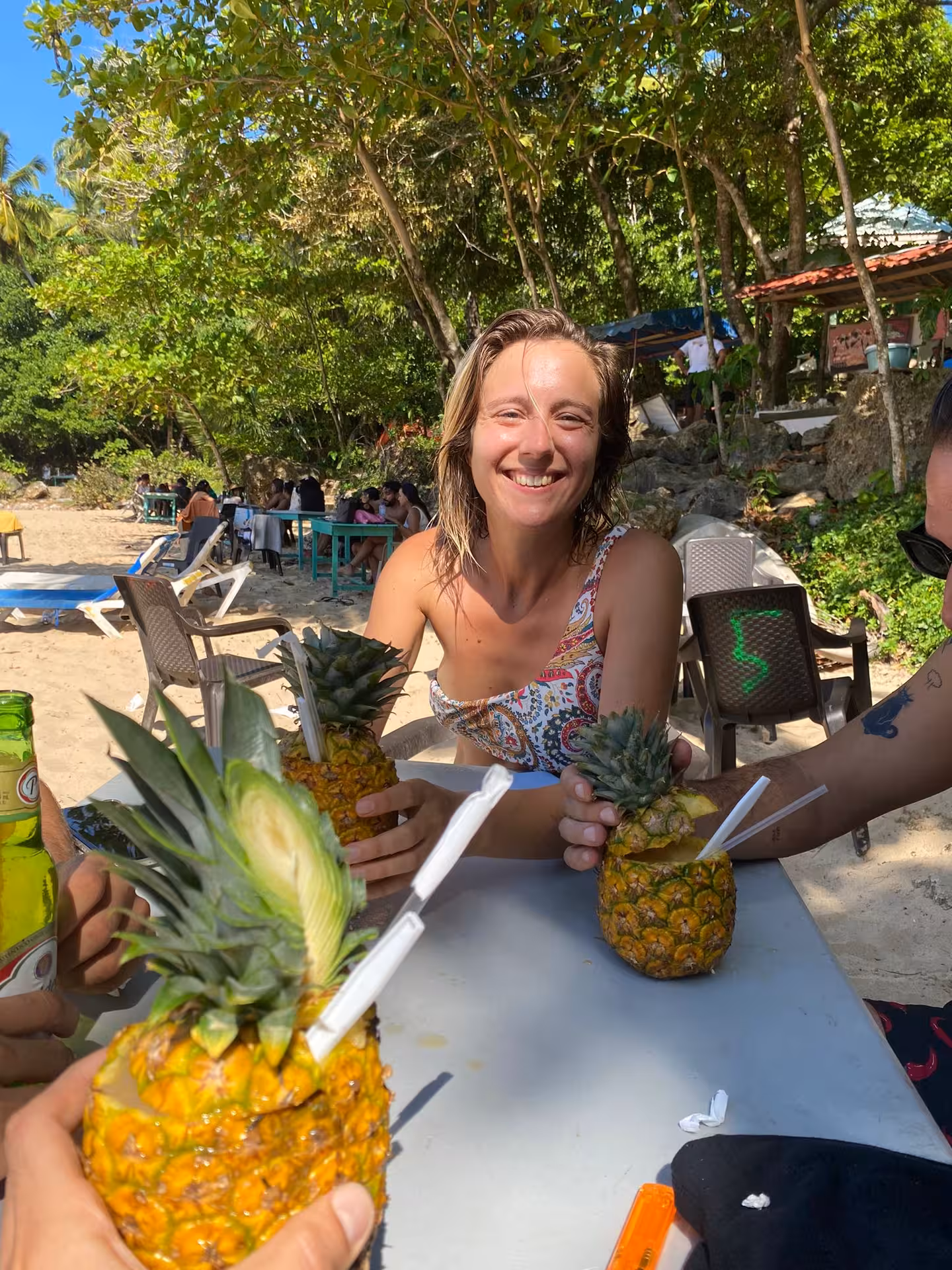 Smiling traveler enjoying fresh pineapple drinks at a beach bar, Dominican culture tour with local flavors