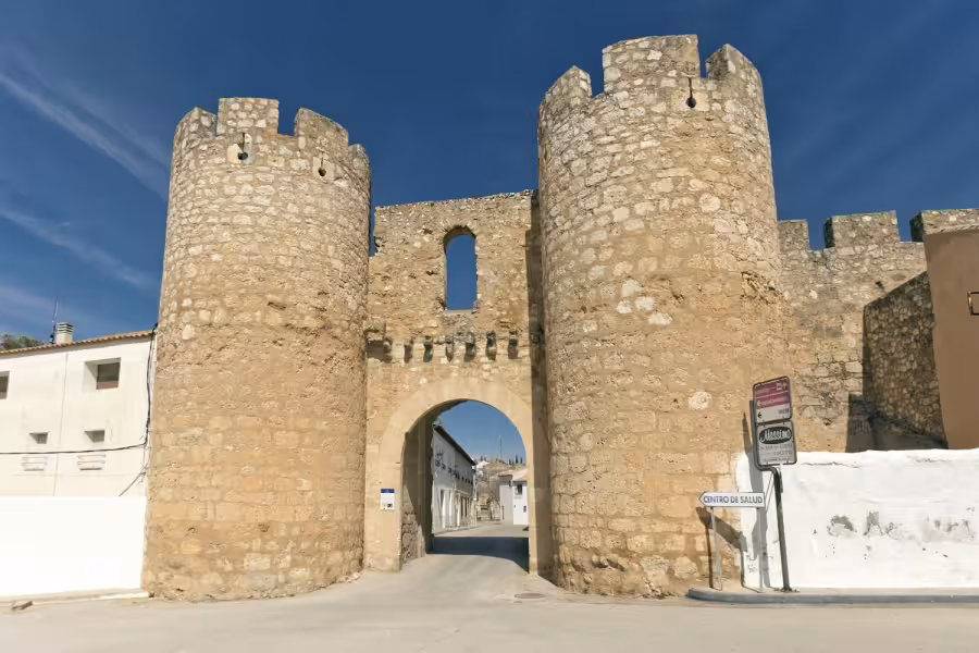 Ancient fortified town gate in La Mancha on the Don Quixote Tour, twin stone towers framing village street