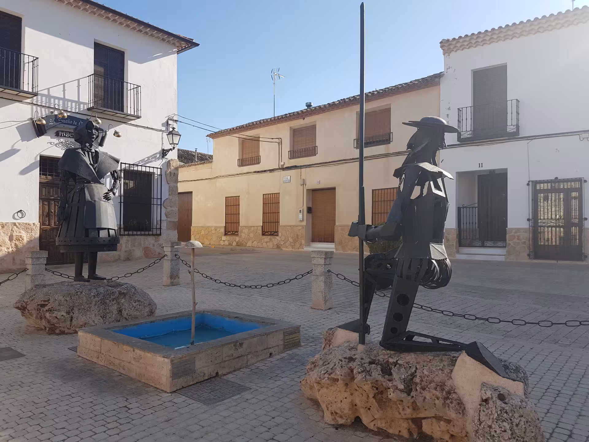 Don Quixote and Sancho Panza metal statues in a La Mancha village square, key stop on Don Quixote Tour