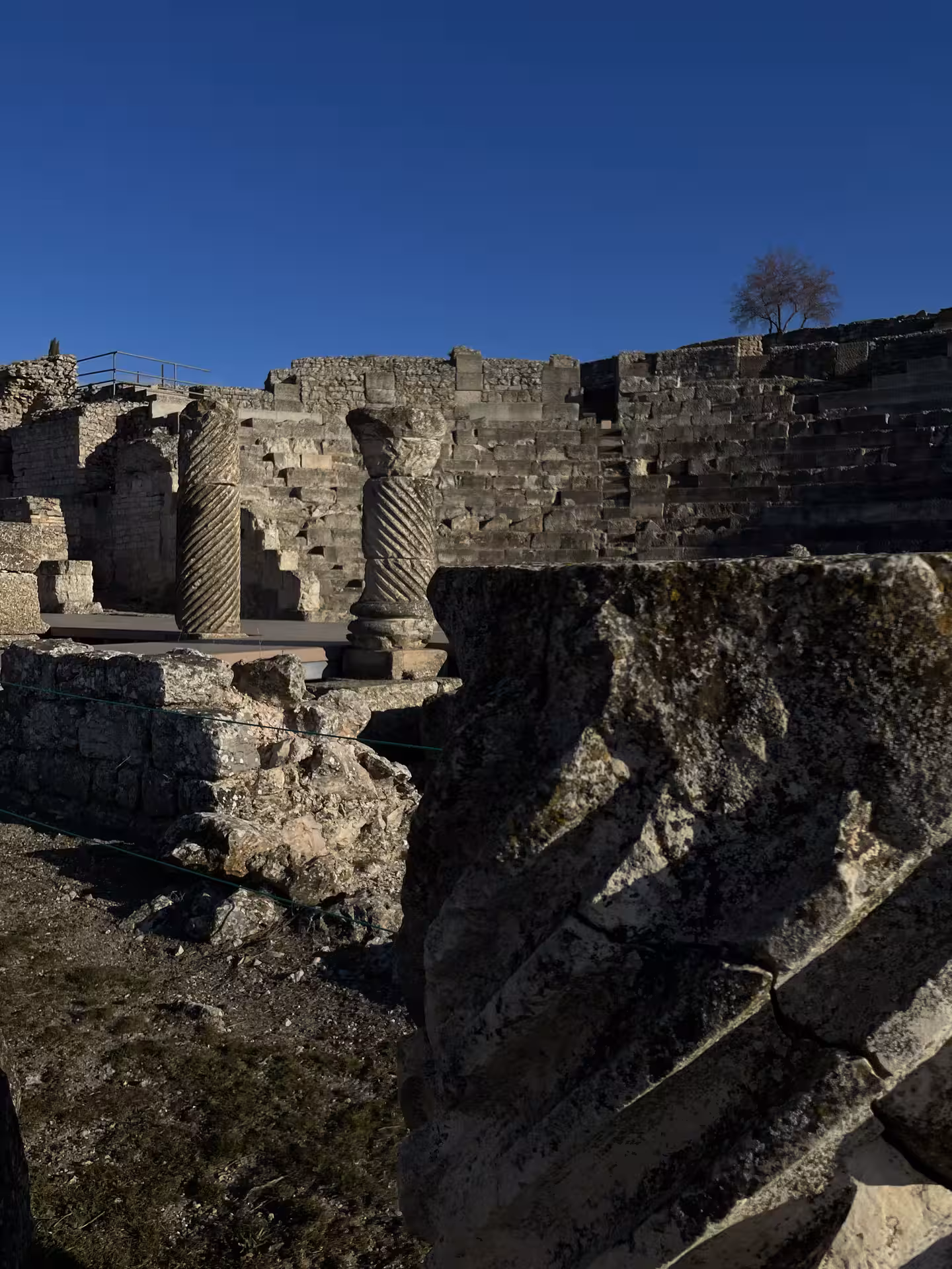 Ancient stone amphitheater ruins with spiral columns, historic site visited on the Don Quixote Tour Spain