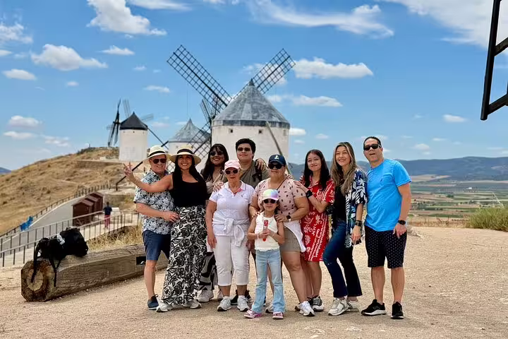 Group of tourists explores Don Quixote windmills in La Mancha, Spain, with guided tour and Toledo culinary experience.