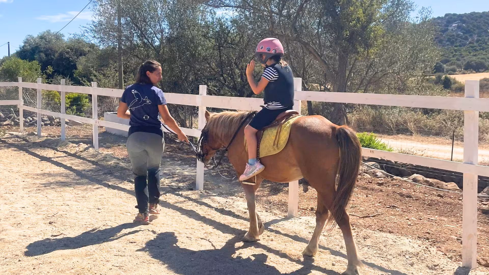 Instructor leading a child on horseback at Dorgali's riding experience, ideal for beginners.