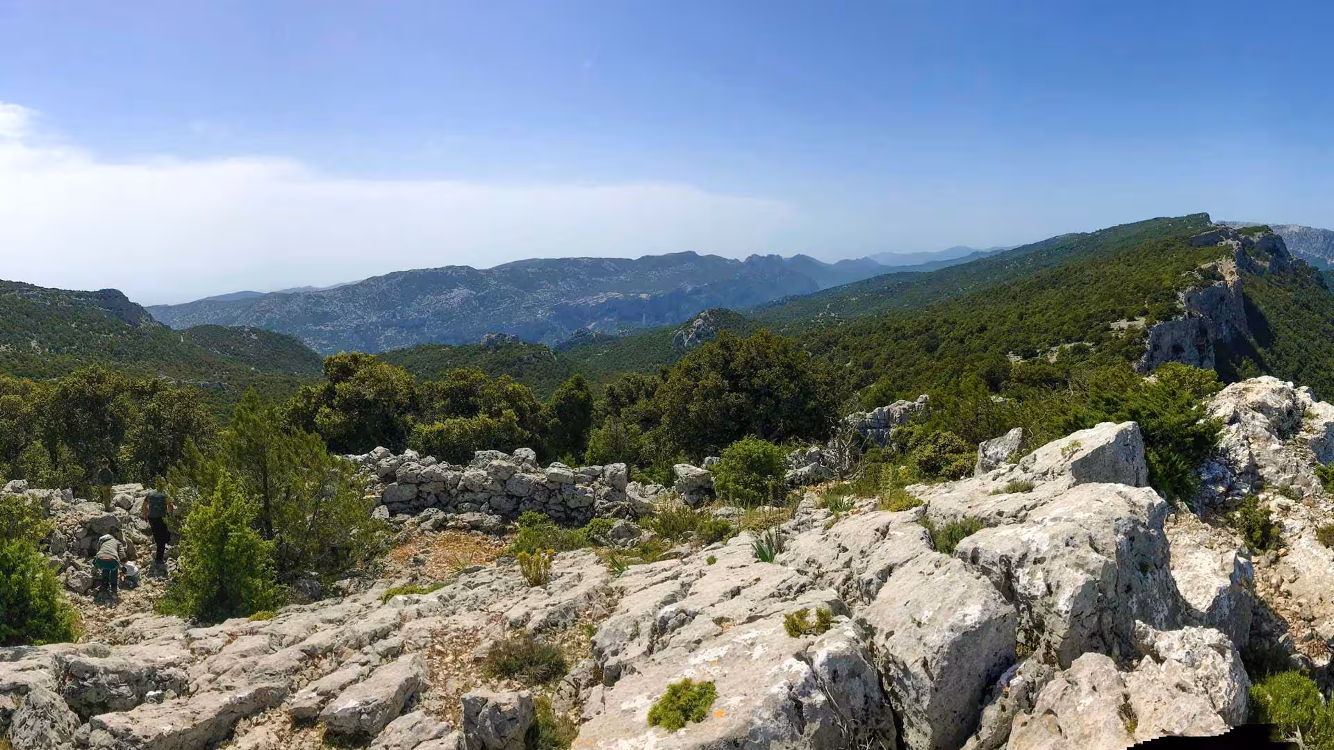 Breathtaking panoramic view of Sardinia's lush green valleys and rugged mountains from a high vantage point.