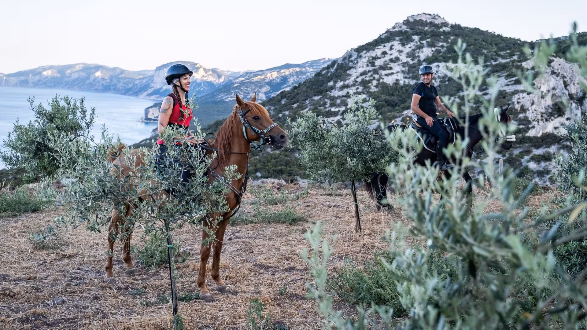 Riders enjoying scenic Dorgali horseback tour with breathtaking views of Gulf of Orosei and lush landscapes.