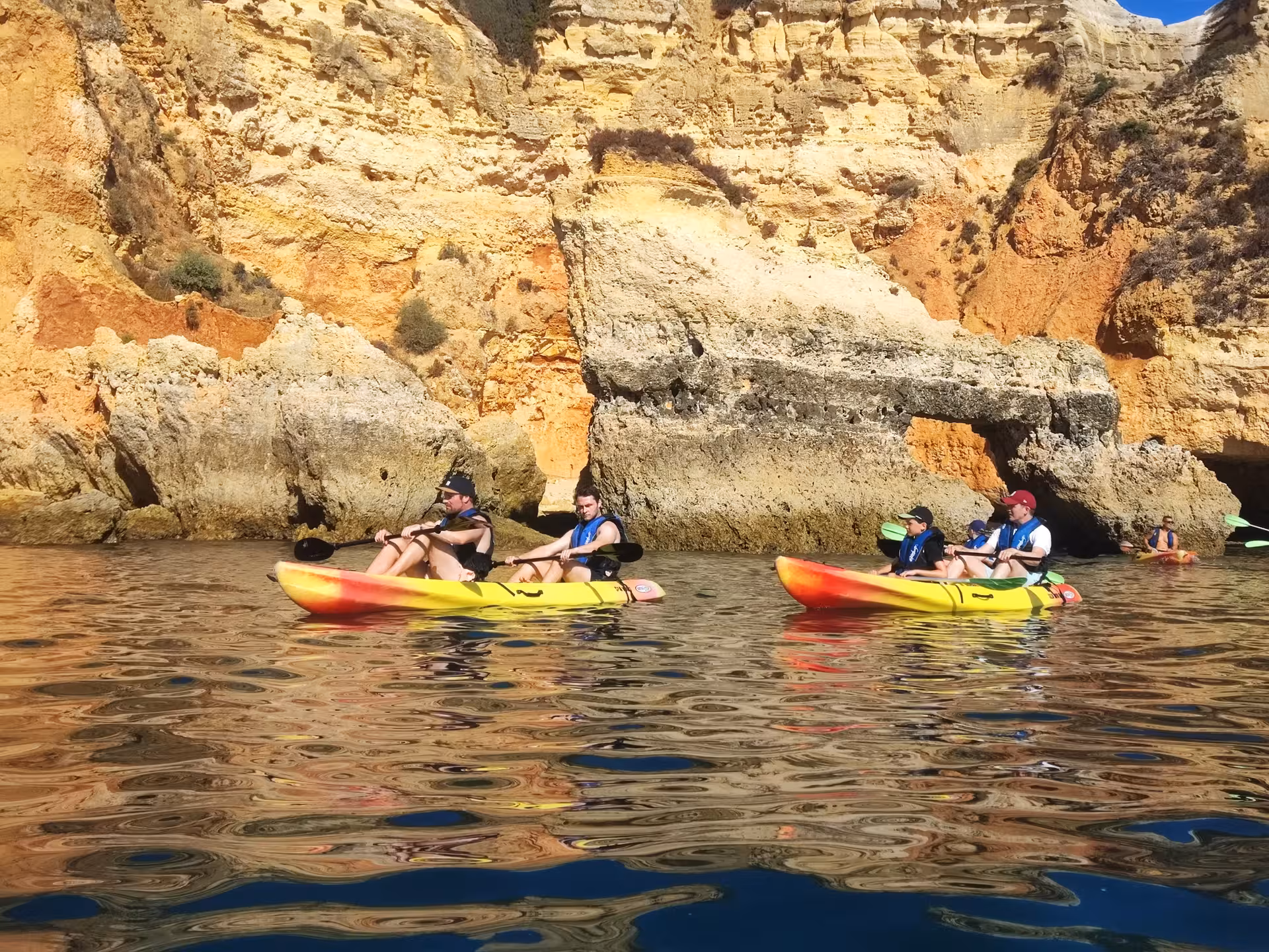 Guided double kayak tour with small group exploring golden sea cliffs and calm coastal waters