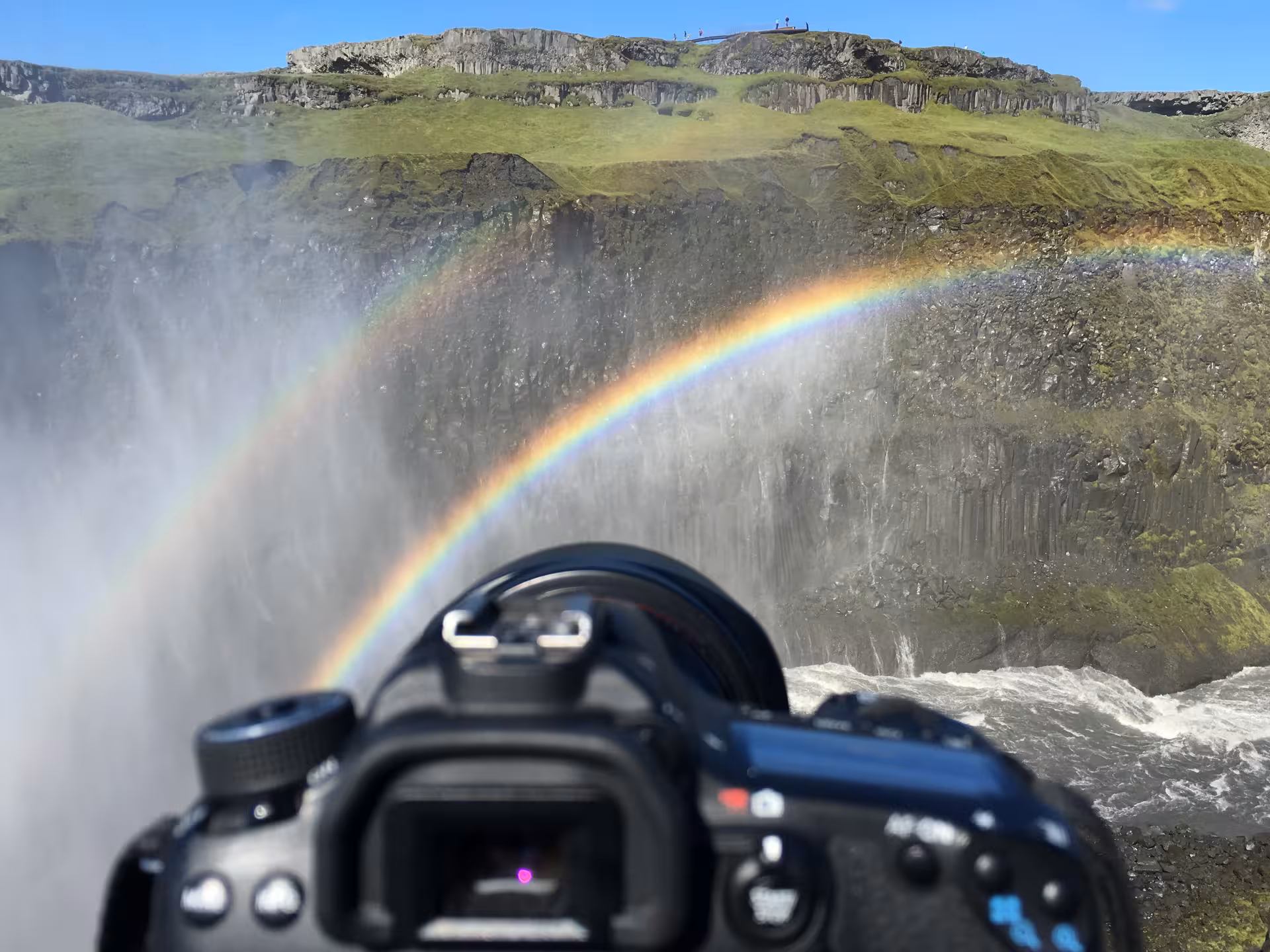 Capture a vibrant double rainbow over a stunning waterfall landscape on a private tailor-made photography tour.