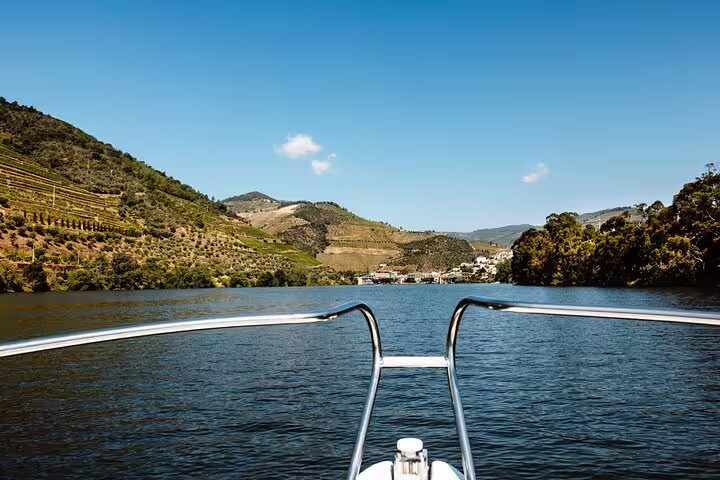View from a boat on the Douro River, surrounded by lush hills and vineyards, perfect for a scenic 4x4 adventure tour.