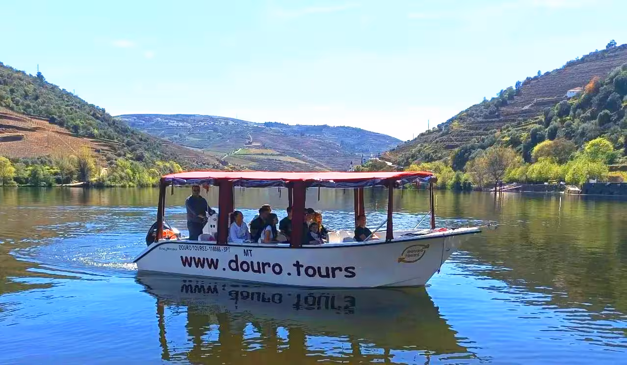 Small boat cruise on Portugal’s Douro River with terraced vineyards, part of an Exclusive Discovery Moment tour