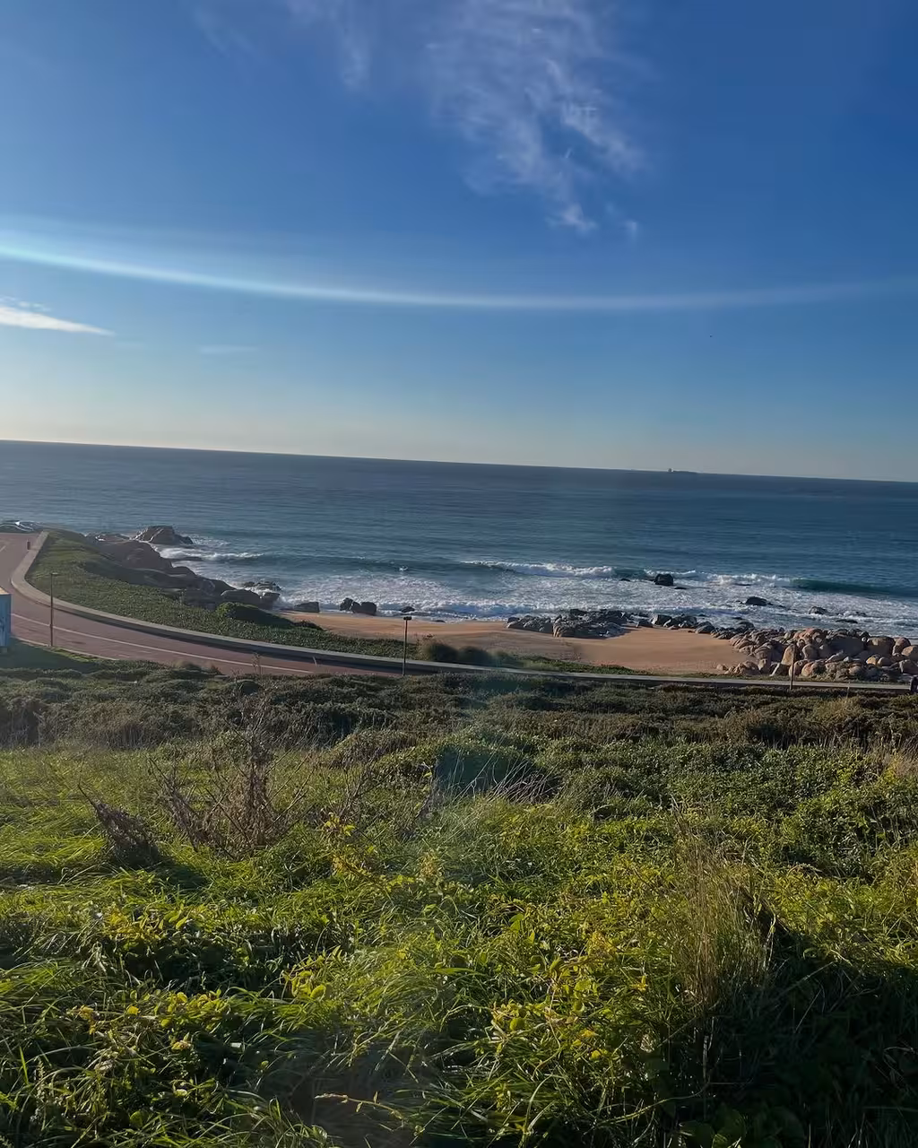 Coastal viewpoint with sandy beach and rocky shore near Porto, a scenic stop on the Douro vintage car tour