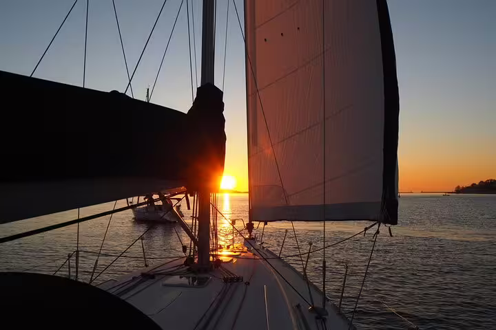 Sailboat gliding on the Douro River at sunset in Porto, capturing serene waters and vibrant skies for a memorable sailing experience.