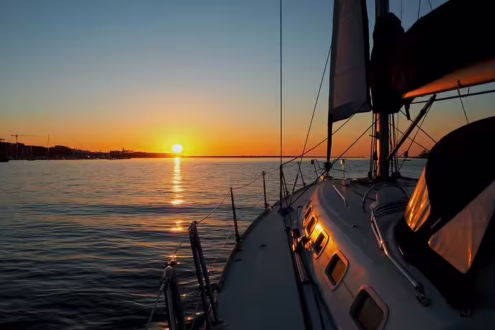 Sailboat on Douro River at sunset in Porto, capturing serene waters and vibrant skies for a memorable sailing experience.