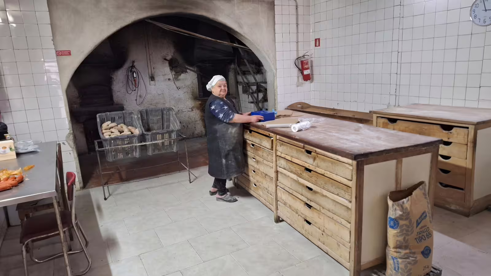 Traditional bakery experience in the Douro Valley with a baker preparing fresh bread, showcasing authentic culinary heritage.