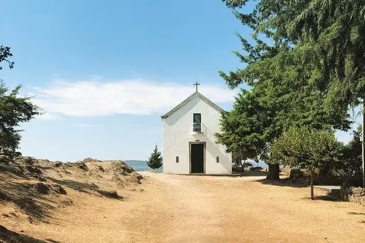 Charming white chapel nestled among trees in the scenic Douro Valley, ideal for sustainable travel enthusiasts.