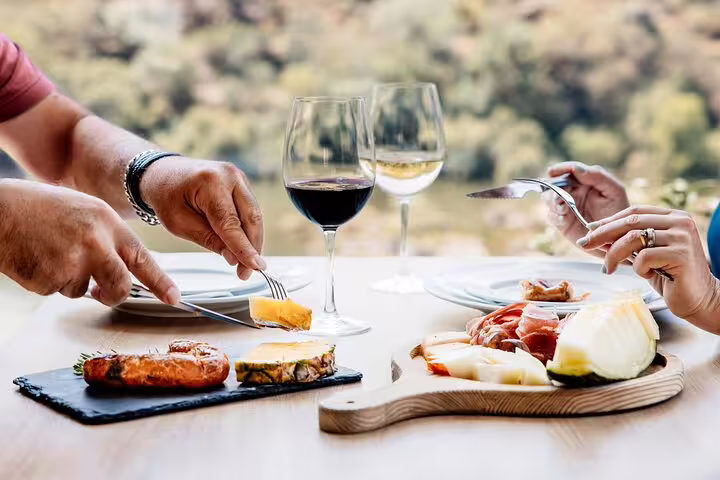 Gourmet lunch with wine and cheese in Douro Valley, highlighting a culinary experience during the tour.