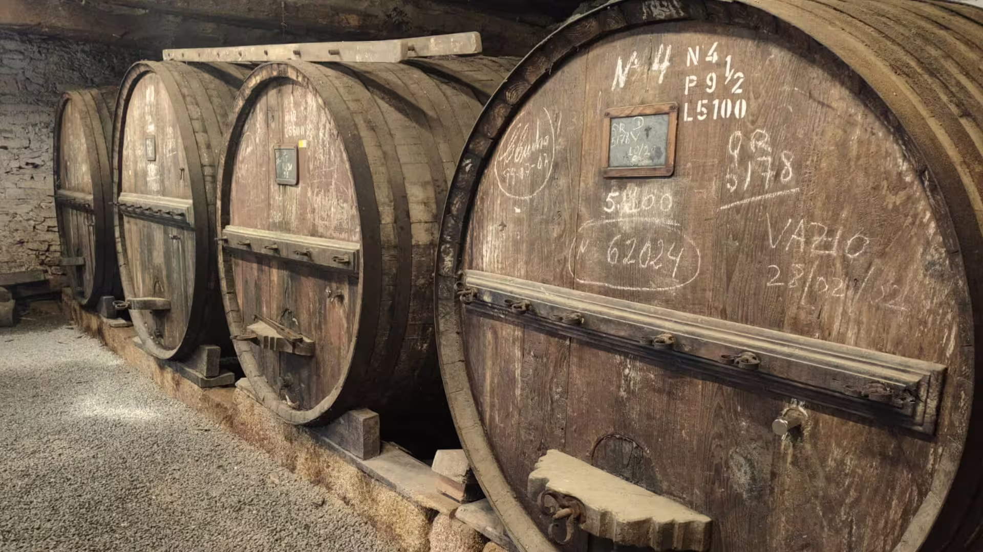 Image of old barrels of Port wine in a winery visit on Cooltour Oporto's Douro Valley Wine Tour from Porto