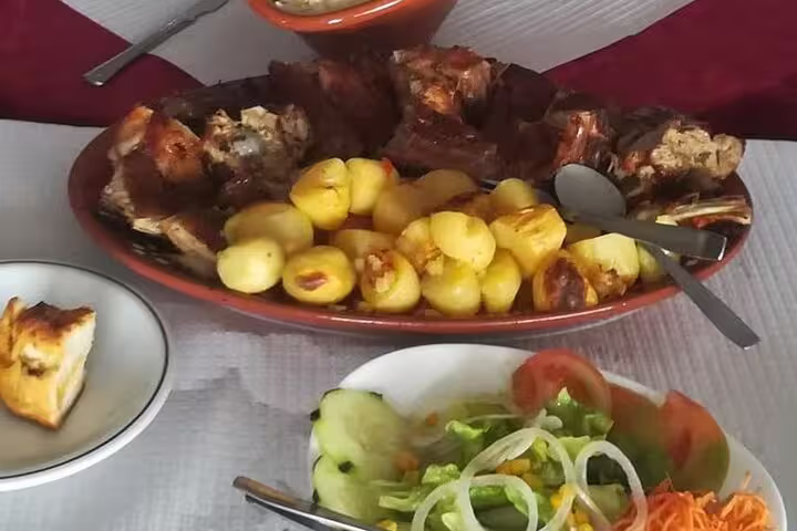 Traditional Portuguese meal with roasted potatoes, meat, and fresh salad, served on a table in the Douro Valley.