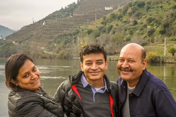 Family enjoying a scenic Douro Valley private tour from Lisbon, surrounded by lush vineyards and the tranquil Douro River.