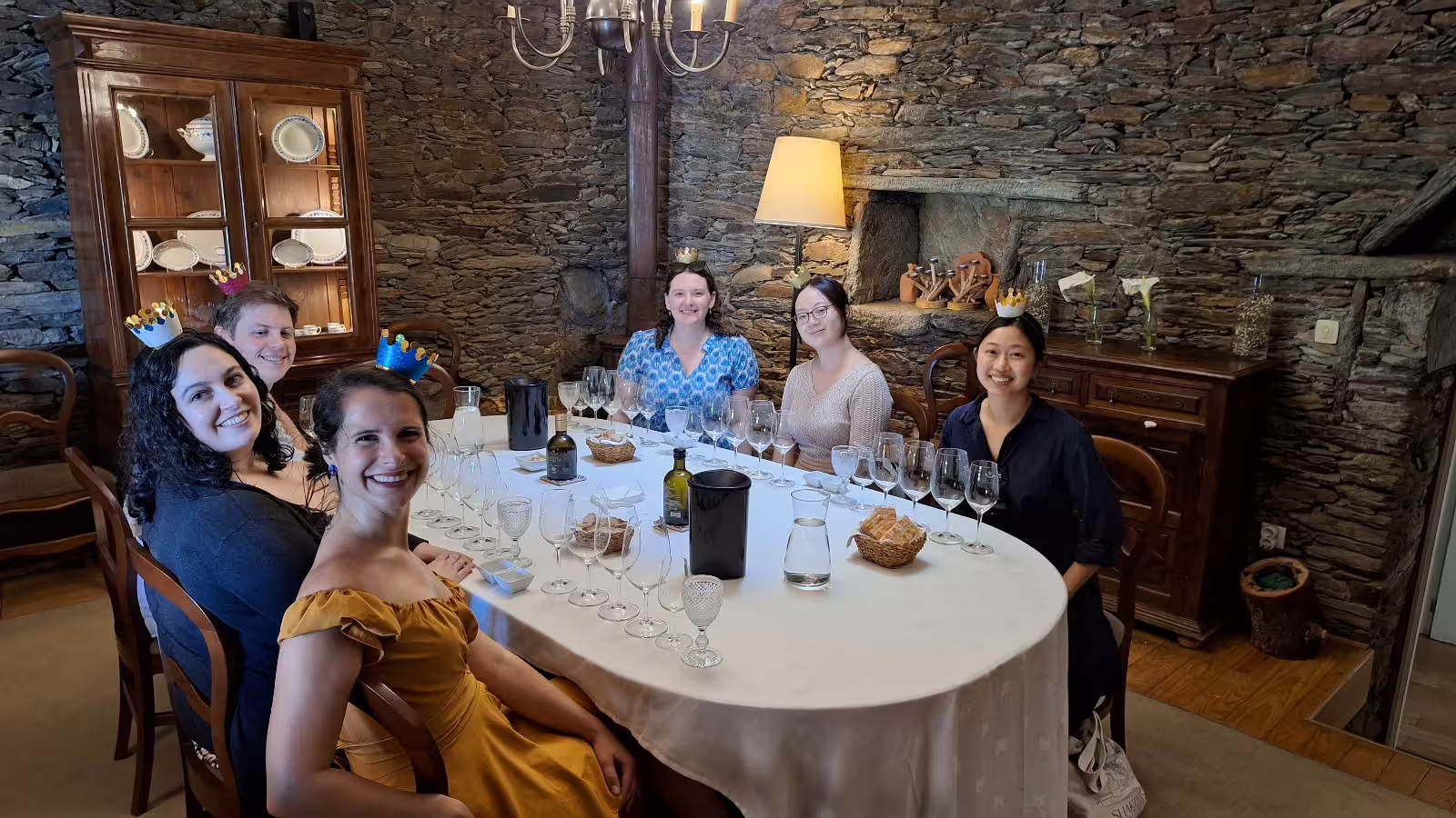 Guests enjoying a private wine tasting at a renowned Douro Valley winery, surrounded by rustic stone walls and elegant decor.