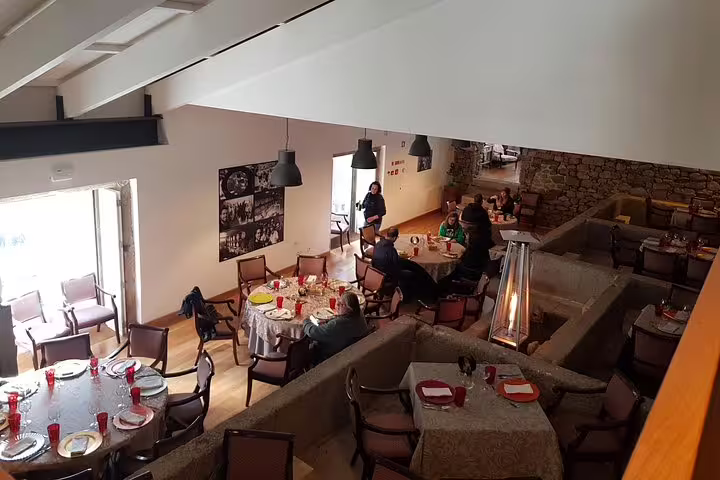Cozy dining area in a Douro Valley vineyard with guests enjoying a meal, enhancing the wine tour experience.