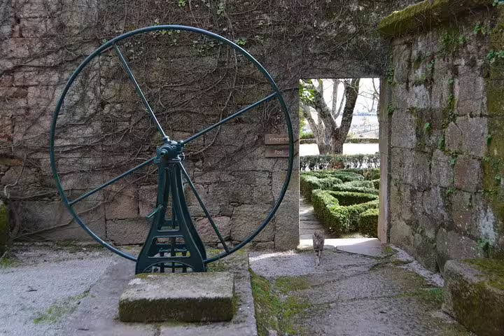 Explore historic vineyard machinery amidst lush gardens on the Douro Valley Wine Tour.