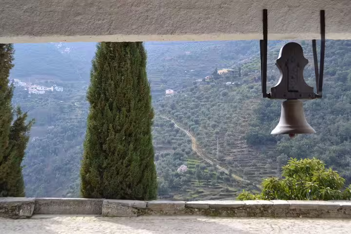 Charming bell overlooking lush terraced landscapes in Douro Valley, ideal spot for a peaceful vineyard tour.