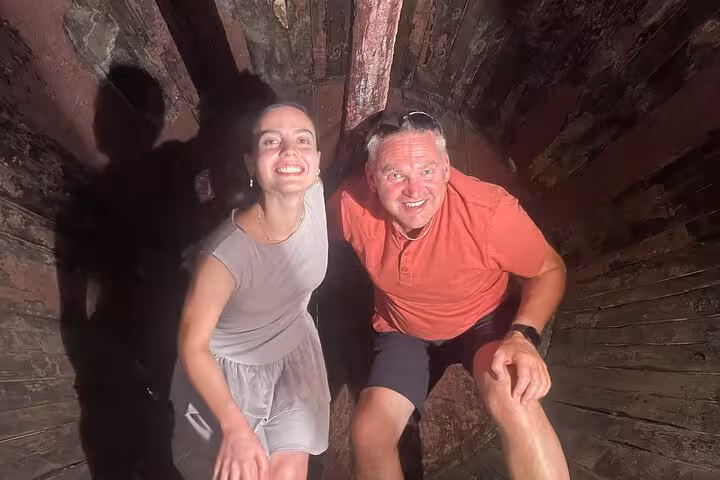 Happy travelers inside a giant Douro wine barrel on a Porto Douro Valley tour featuring two wine regions, boat trip & lunch