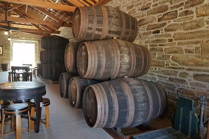 Traditional wine barrels stacked in a rustic cellar at a Douro Valley vineyard, highlighting authentic wine production.