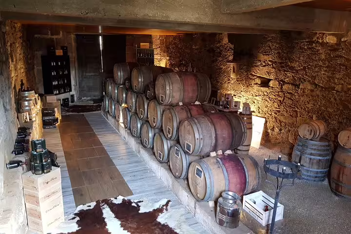 Rustic wine cellar in Douro Valley with stacked barrels, showcasing the traditional Portuguese winemaking process.