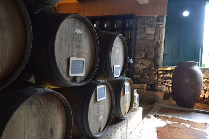 Cozy Douro Valley wine cellar with stacked oak barrels, offering a glimpse into traditional wine aging processes.