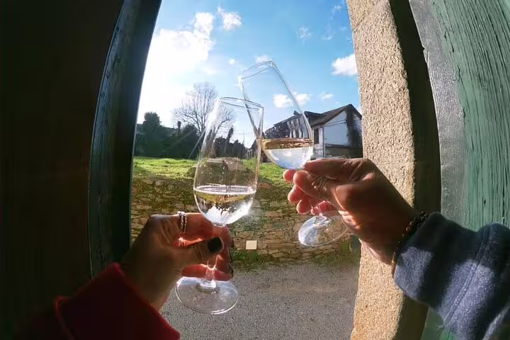 Three wine glasses clinking in celebration against a sunny backdrop in Douro Valley.