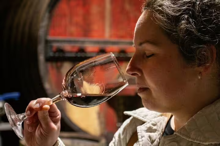 Woman savoring red wine aroma in Douro Valley winery, showcasing private luxury wine tasting experience.