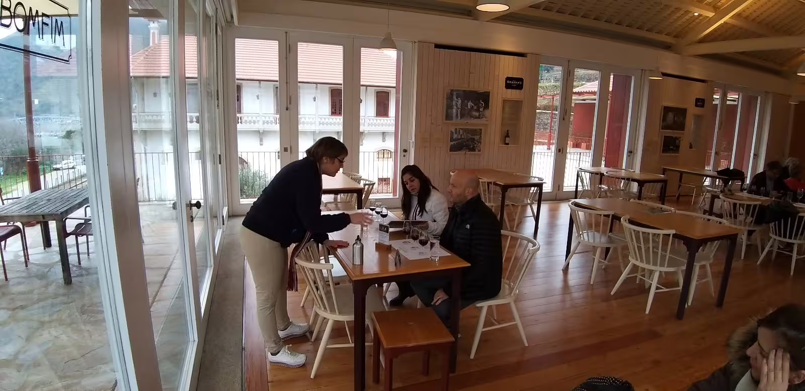 Guests enjoy a wine tasting experience at a charming Douro Valley winery during a private tour, surrounded by scenic views.