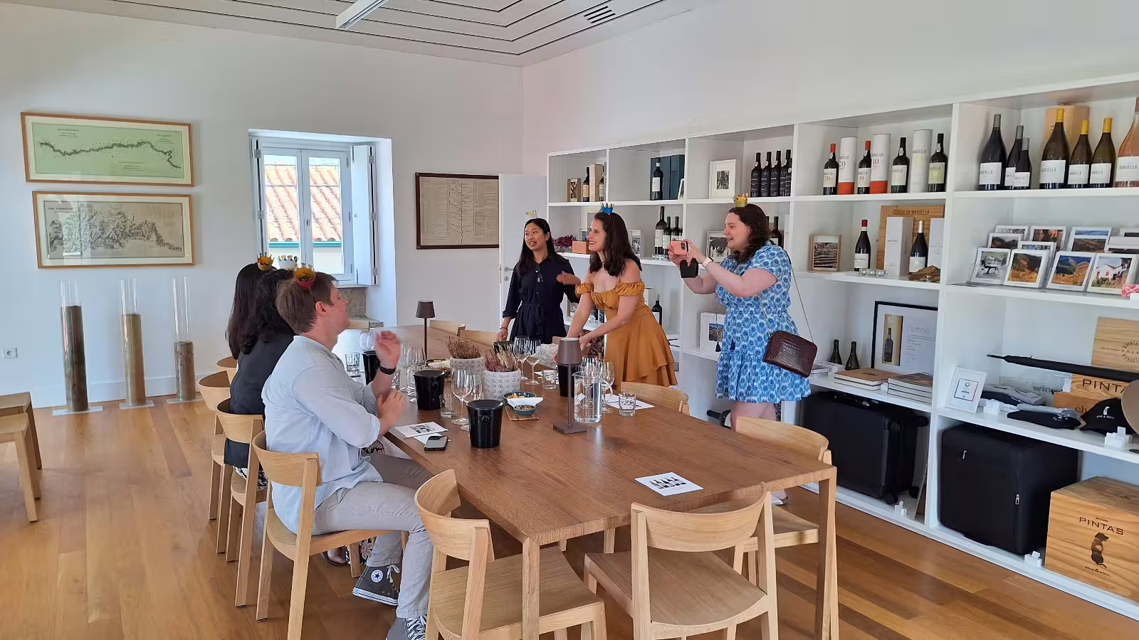 Group enjoying a wine tasting experience at a renowned Douro Valley winery, surrounded by elegant decor and wine displays.