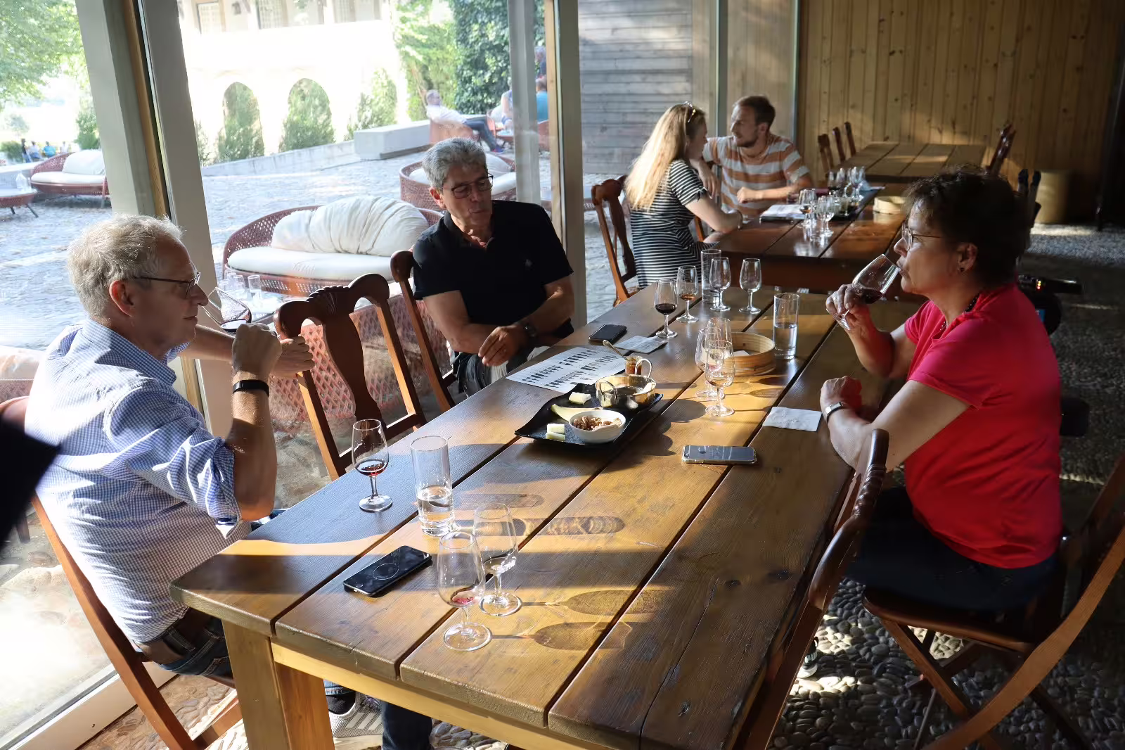 Guests enjoy wine tasting at a rustic Douro Valley winery, highlighting Portugal's renowned wine tourism experience.