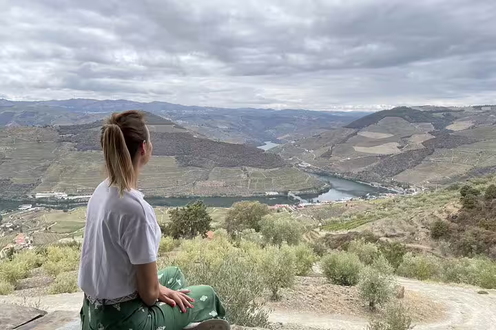 Woman admiring the breathtaking Douro Valley landscape from a scenic viewpoint, ideal for a river cruise adventure.