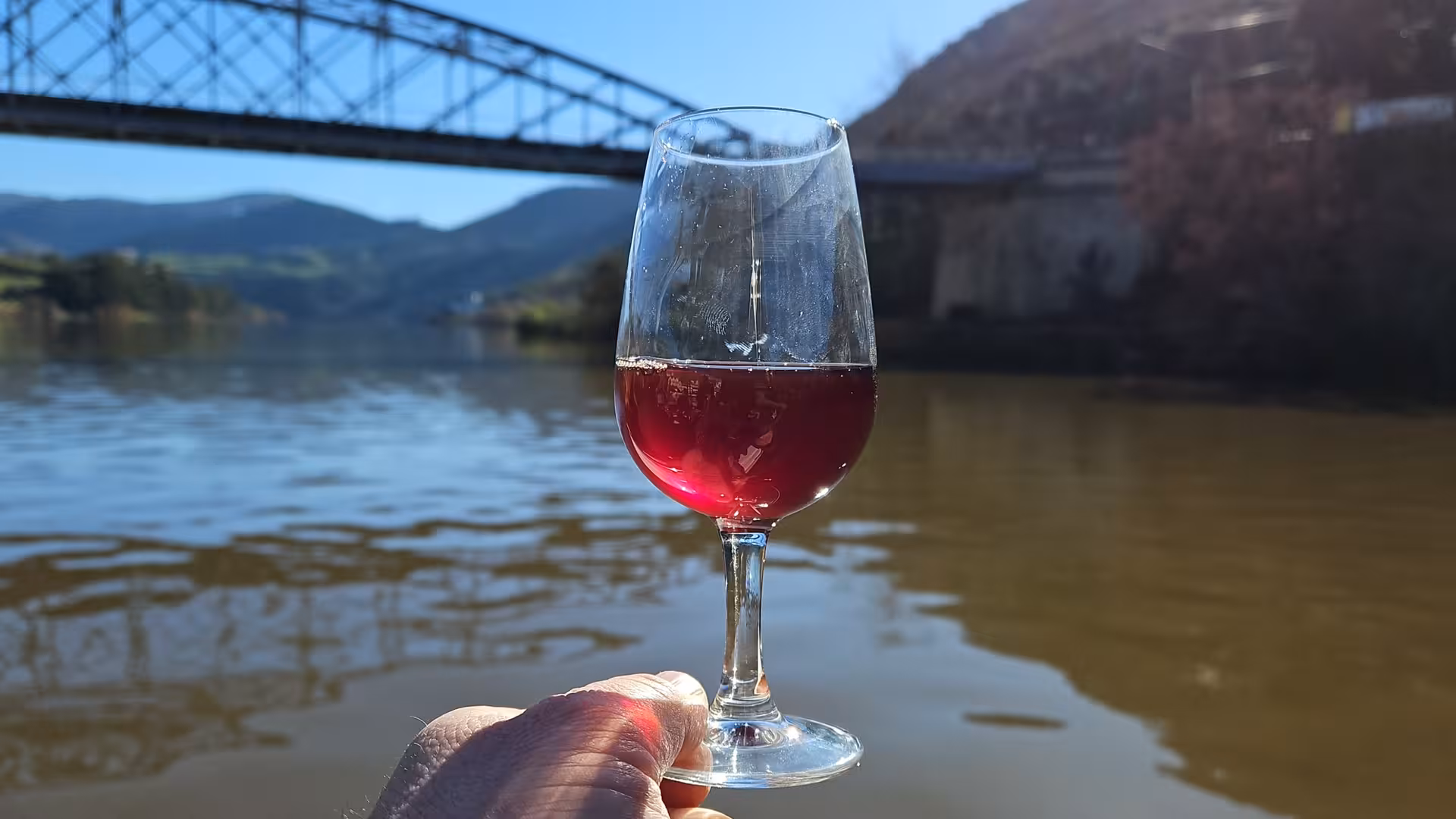 Glass of Douro wine during river boat trip, part of Douro Valley tour from Gaia with winery tasting experience
