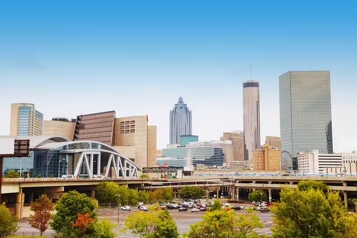 Downtown Atlanta skyline with highways, green trees, and modern skyscrapers on a clear day