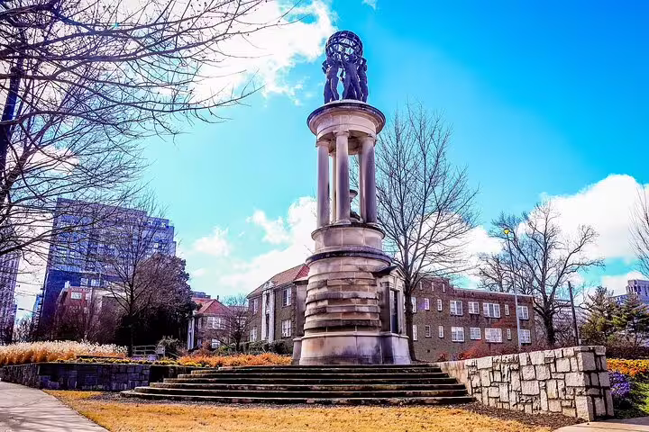 Historic stone monument with columned pedestal and bronze statue in Downtown Atlanta park