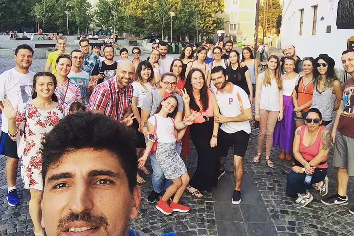 Large group of tourists smiling for a selfie during a guided Dracula tour in Bucharest city square