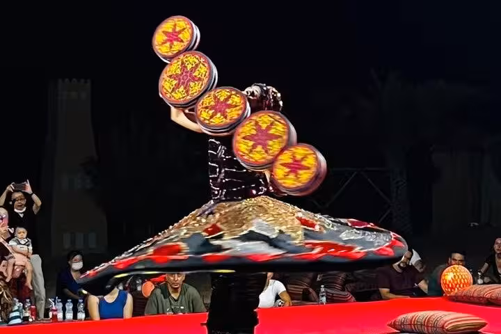 Evening desert camp show on Dubai to Abu Dhabi multi day adventure tour, traditional tanoura dance performance