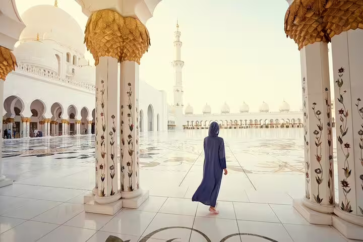 Visitor in Sheikh Zayed Grand Mosque courtyard, highlight of Dubai private day trip to Abu Dhabi mosque and palace