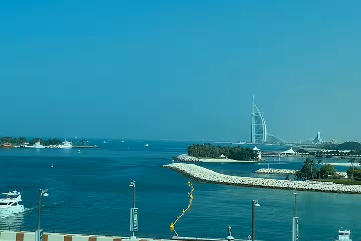 Burj Al Arab over Dubai coastline seen from Palm Jumeirah, The View at The Palm entrance included tour