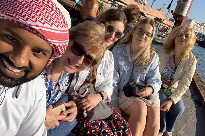 Guests enjoy an abra ride in Dubai Creek Old Town souks on a private half-day city tour