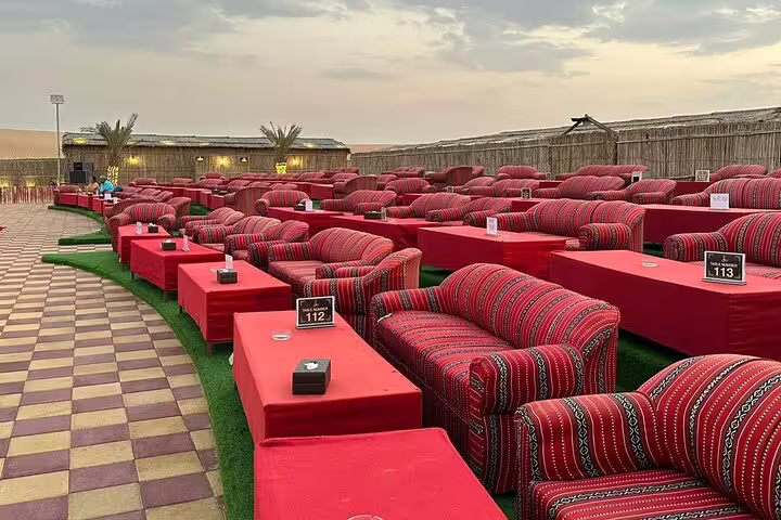 Comfortable seating area set up for a BBQ dinner at a Dubai desert safari camp.