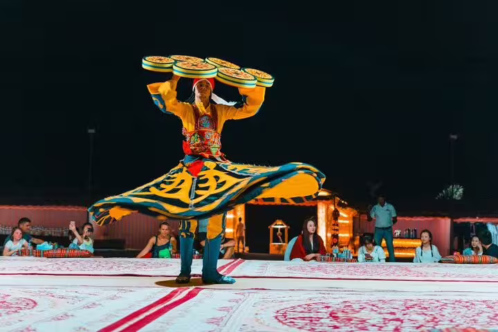 Traditional dancer performs vibrant show during Dubai desert safari evening entertainment.