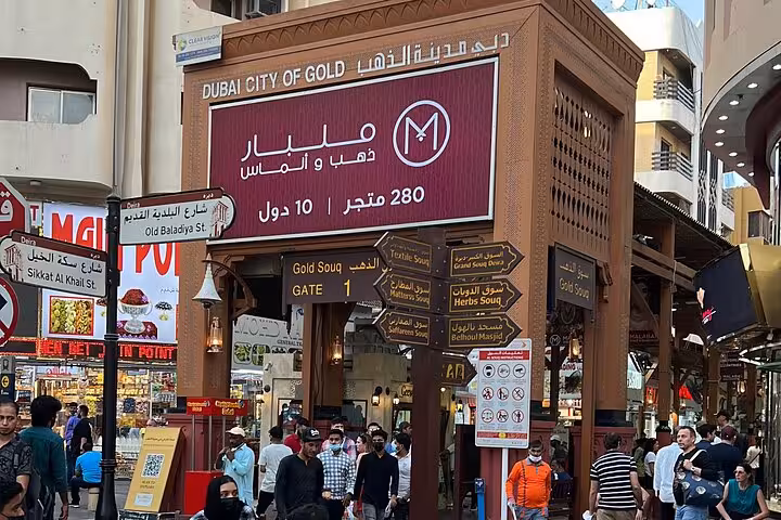 Dubai Gold Souk entrance in Deira on private city tour, bustling market streets and Arabic signboards